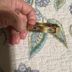 Gold Tone Hinged Bangle Bracelet with Blue Crystal Eye Accents